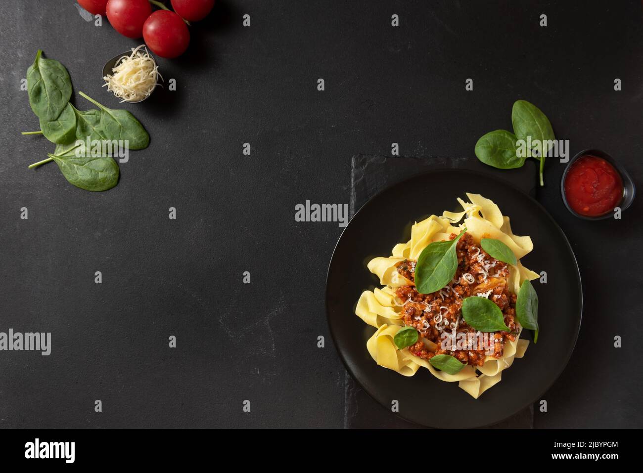 Classic food in Italy. Pasta with bolognese sauce on a black plate Stock Photo