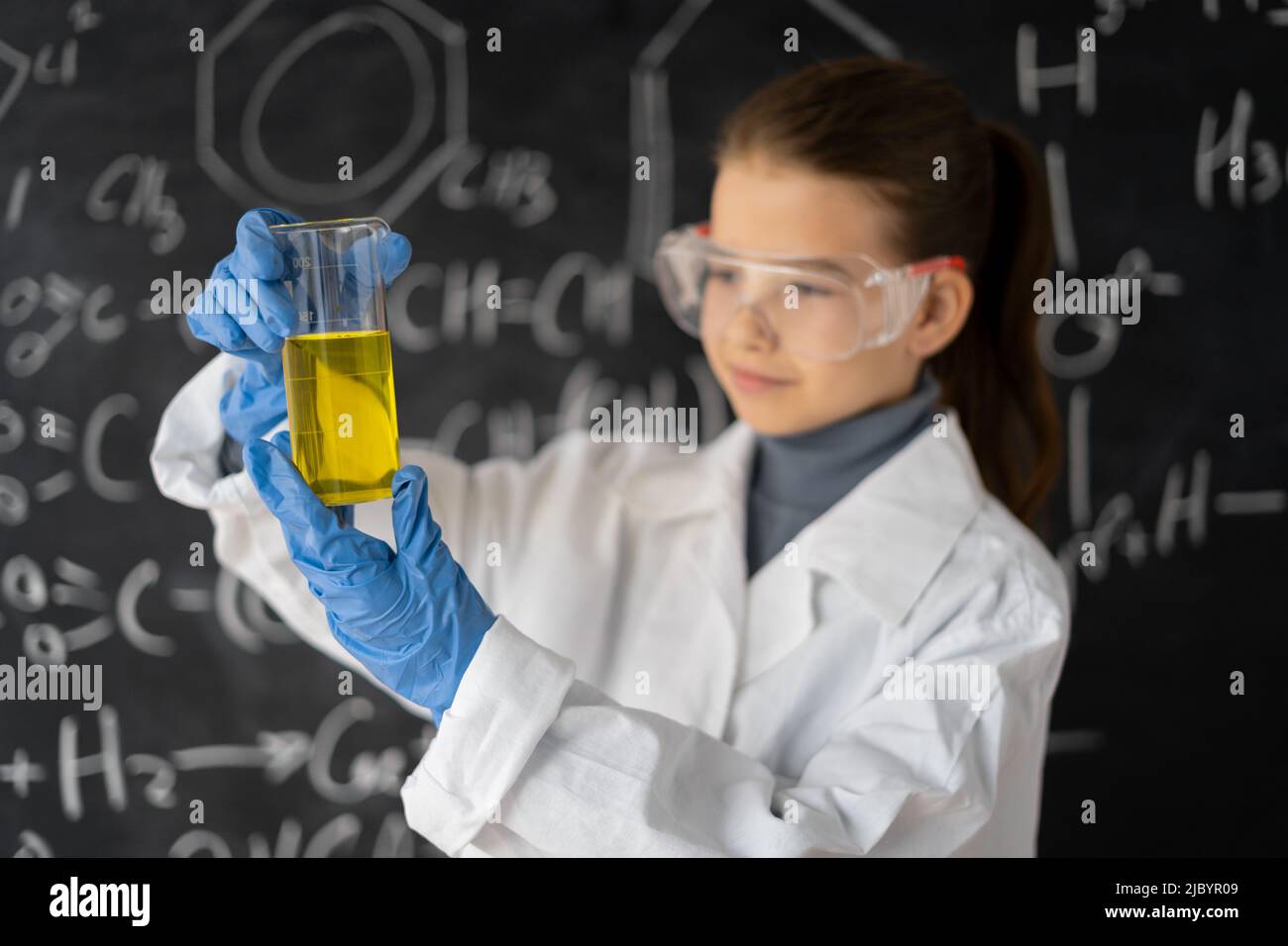 scientist child with glasses in lab coat with chemical flask, little