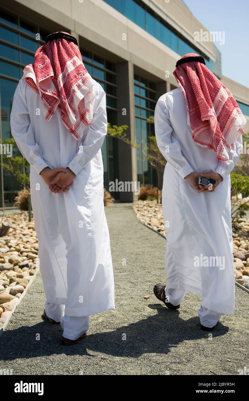 Middle Eastern men in traditional clothing walking on path Stock Photo