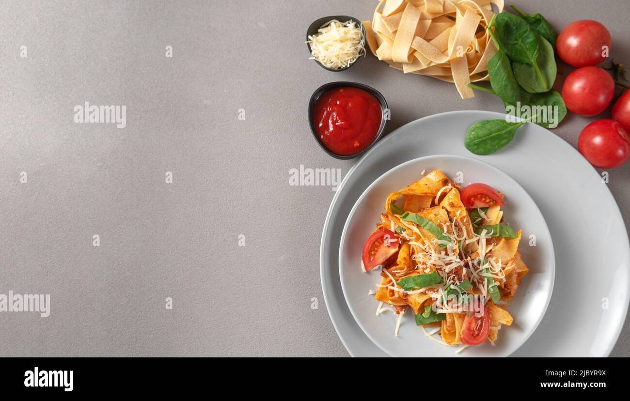 Italian pasta on gray background with ingredients Stock Photo
