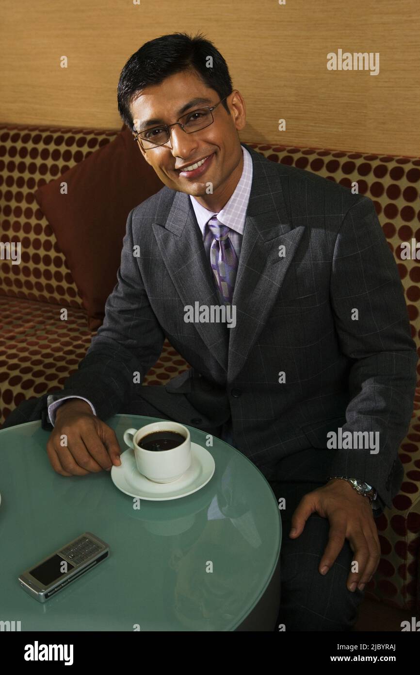 Indian businessman drinking coffee in cafe Stock Photo