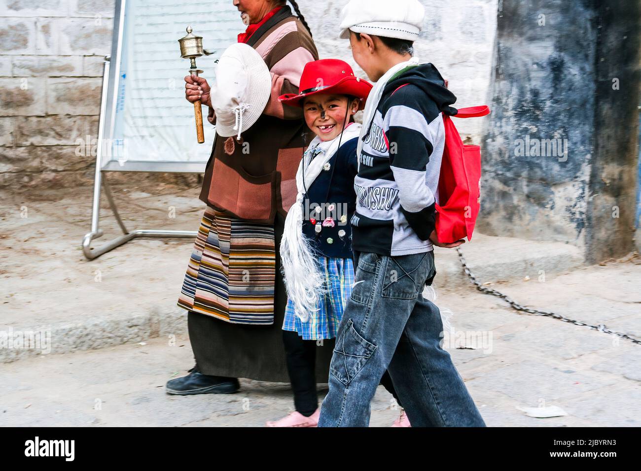 A Tibetan mother with her two children walks to the exit of Drepung Monastery in Lhasa, Tibet. Stock Photo