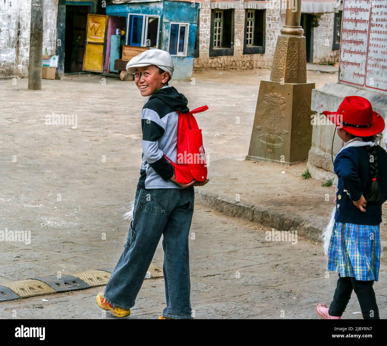 A young Tibetan boy looks back at the photographer as he walked past him at Drepung Monastery. Stock Photo