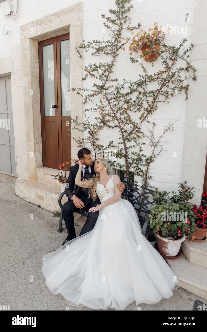 Vertical of wedding, married couple in love, sitting on the bench near