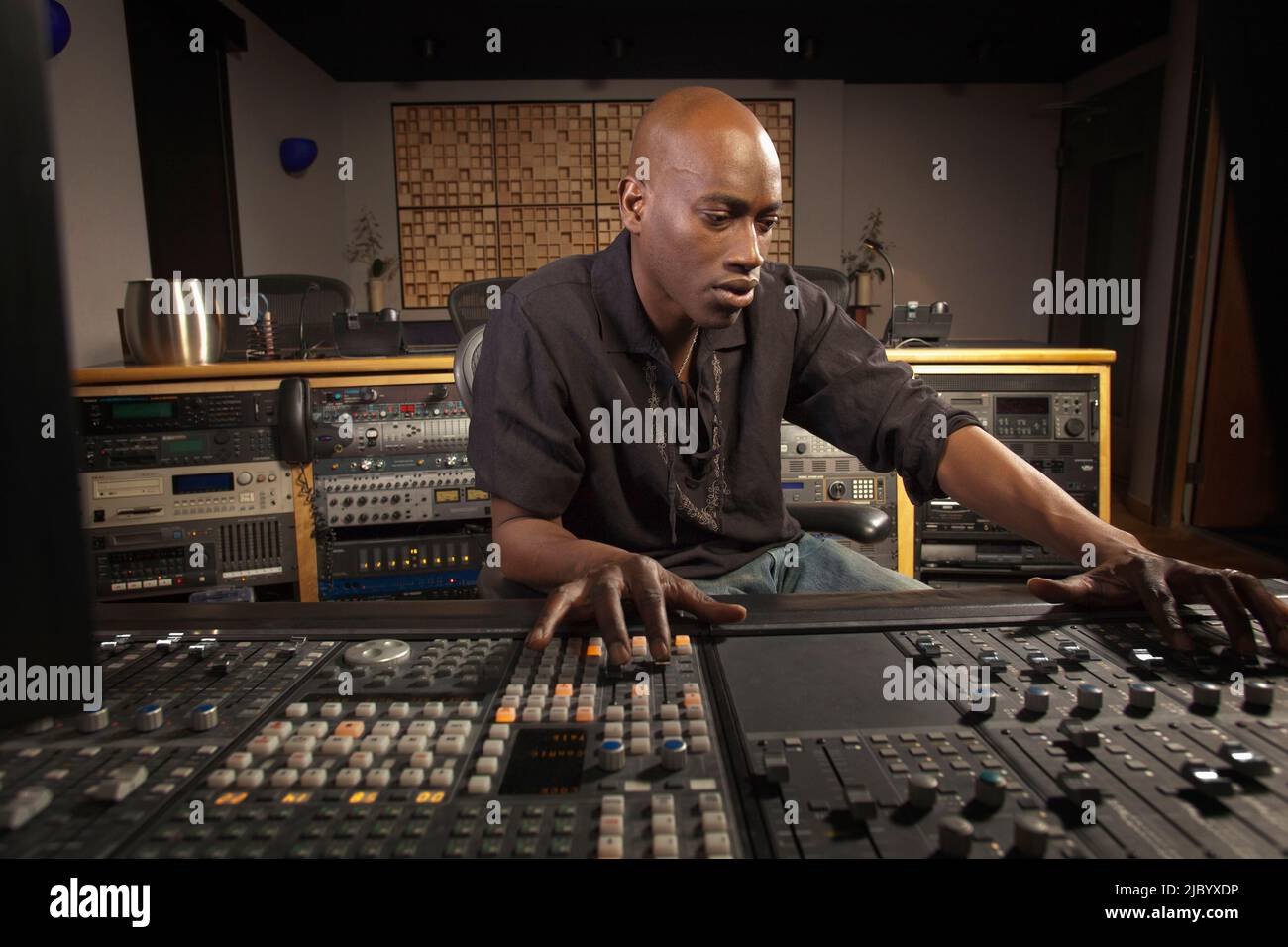 African American man working at audio control panel Stock Photo