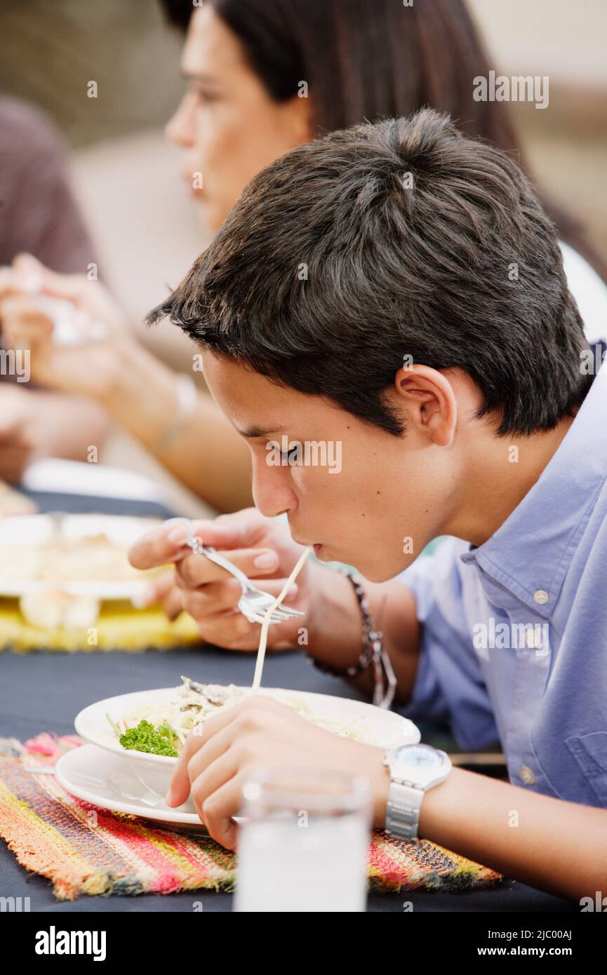 Teenage boy eating pasta Stock Photo