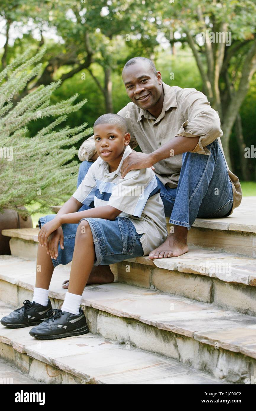 Father and son sitting on steps Stock Photo - Alamy