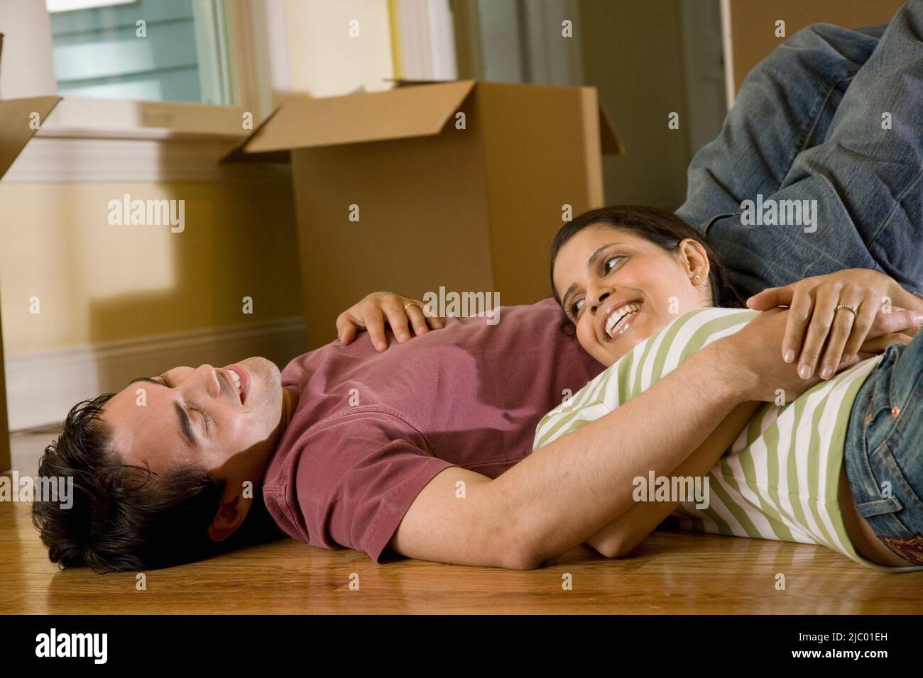 Hispanic couple on floor next to moving boxes Stock Photo