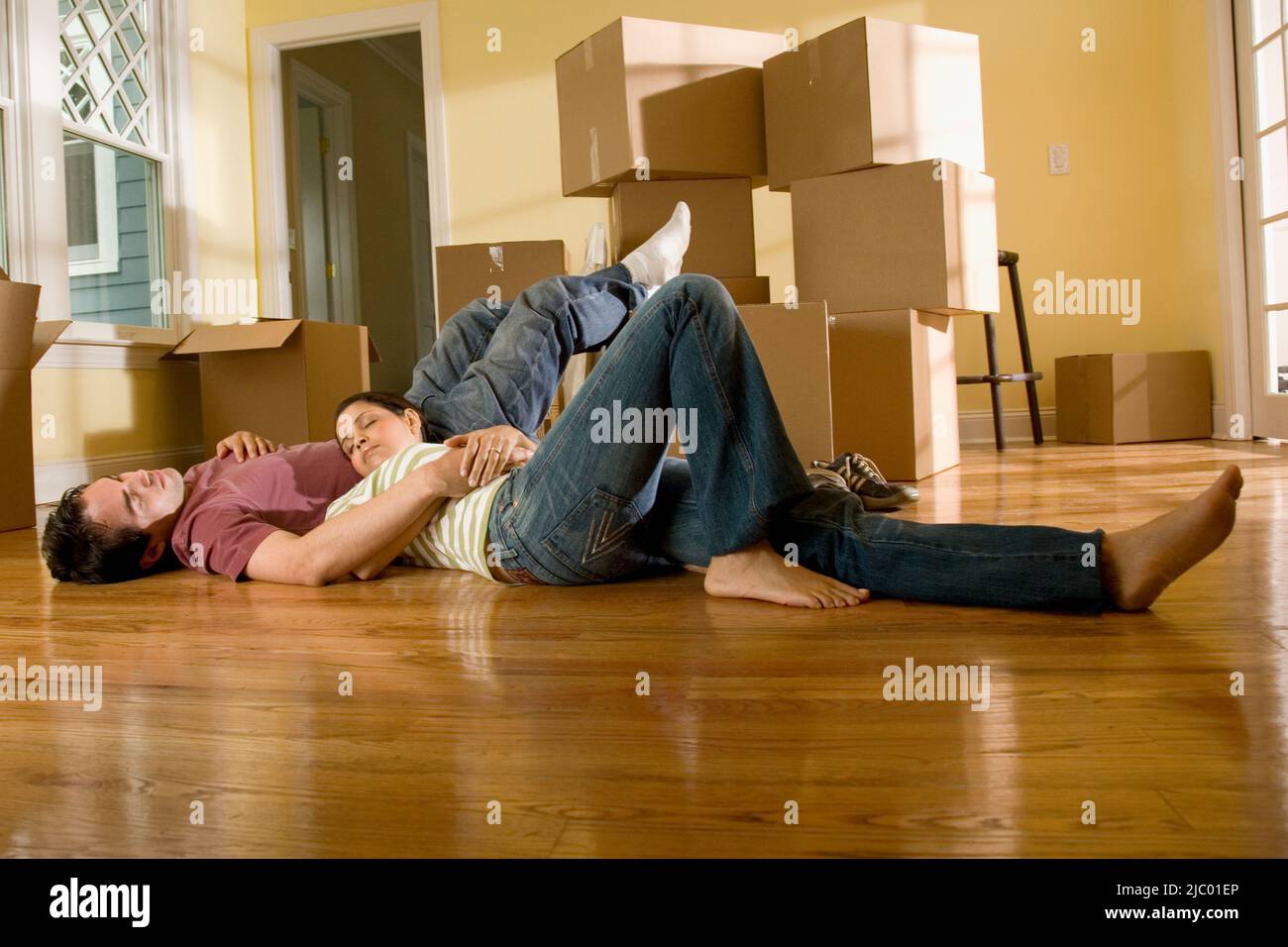 Hispanic couple on floor next to moving boxes Stock Photo