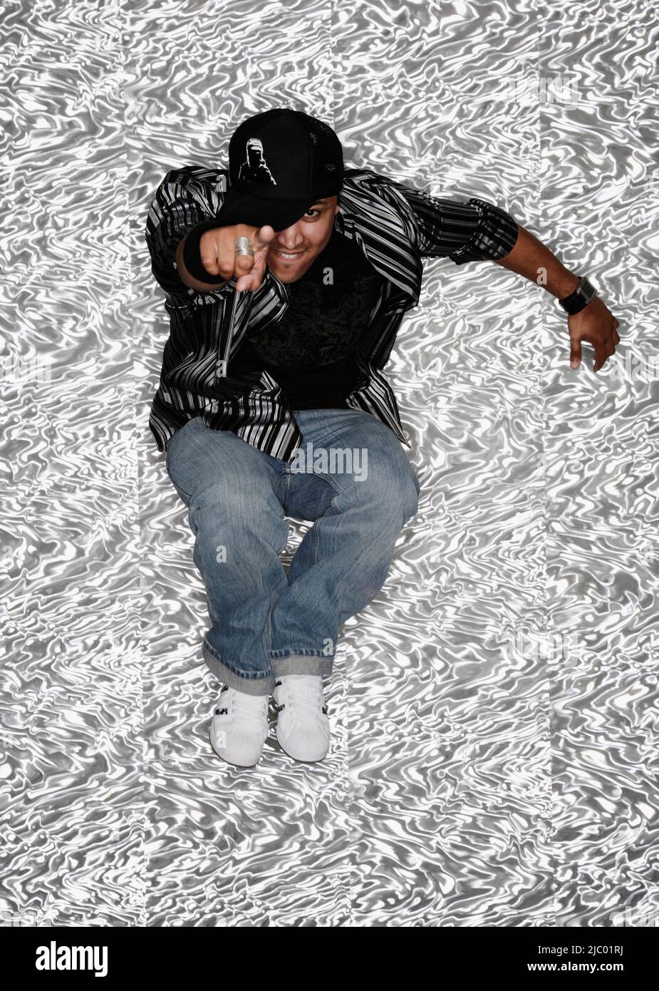 Hispanic man pointing and jumping Stock Photo