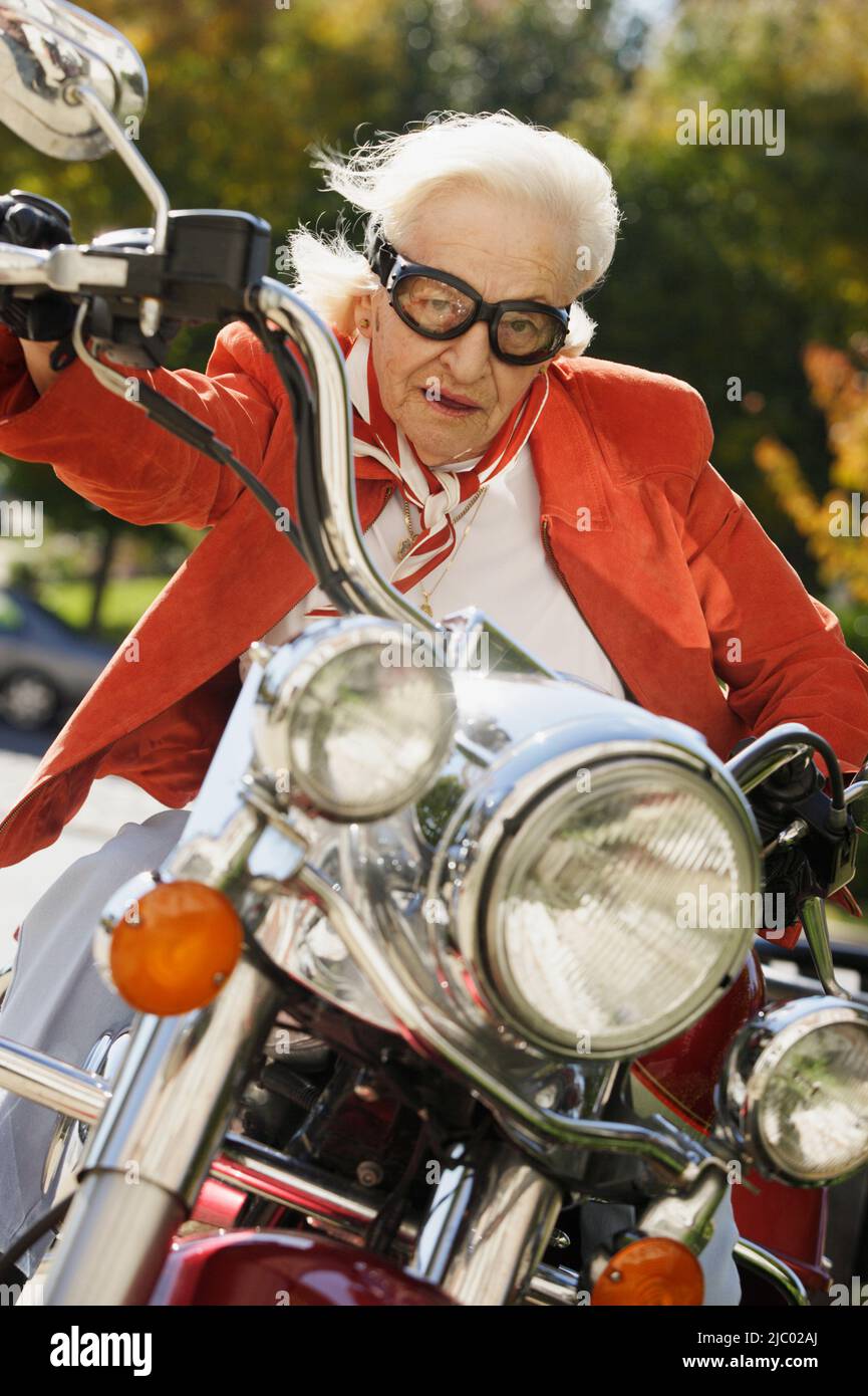 Elderly woman driving a motorcycle Stock Photo