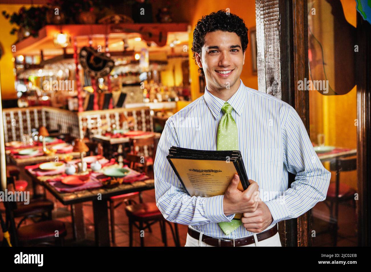 Portrait of waiter holding menus in restaurant Stock Photo Alamy