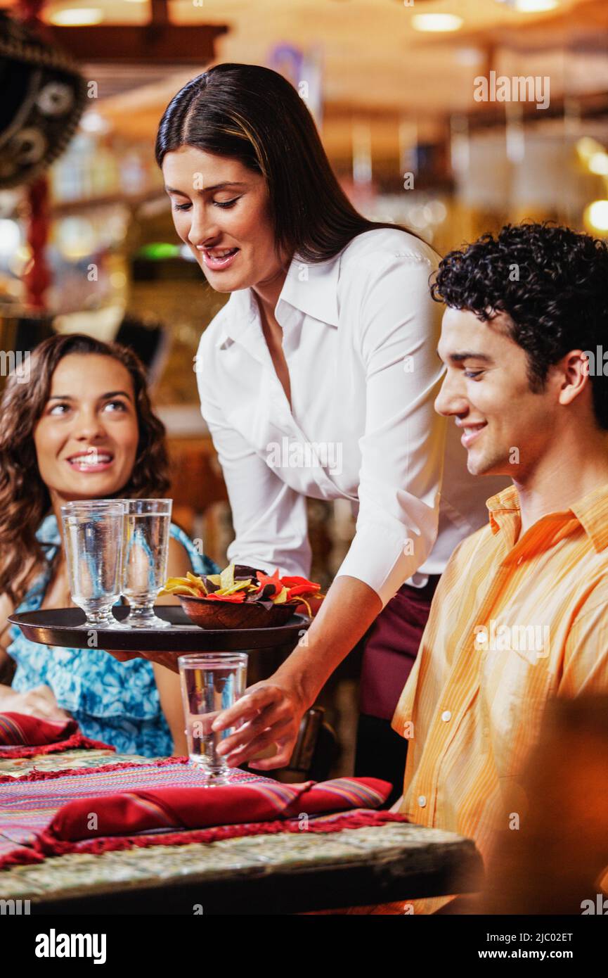 Waitress serving couple water at restaurant Stock Photo Alamy