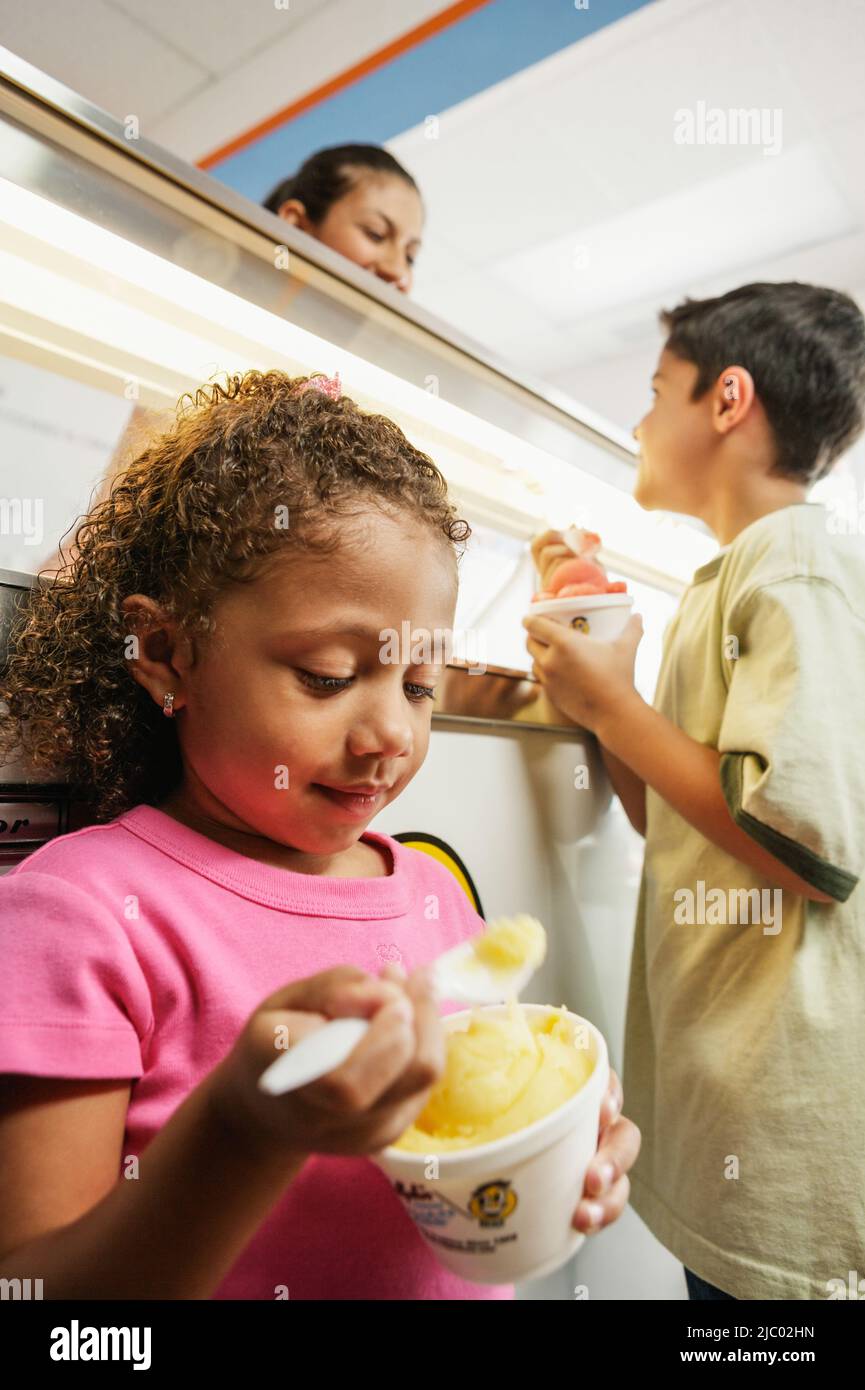 Brother and sister eating ice cream in ice cream shop Stock Photo