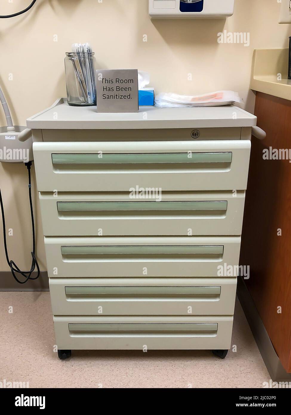 Five Drawer Medical Cabinet in a doctors office or clinic, with sign that reads This Room Has Been Sanitized. Hygiene for patient health and safety. Stock Photo