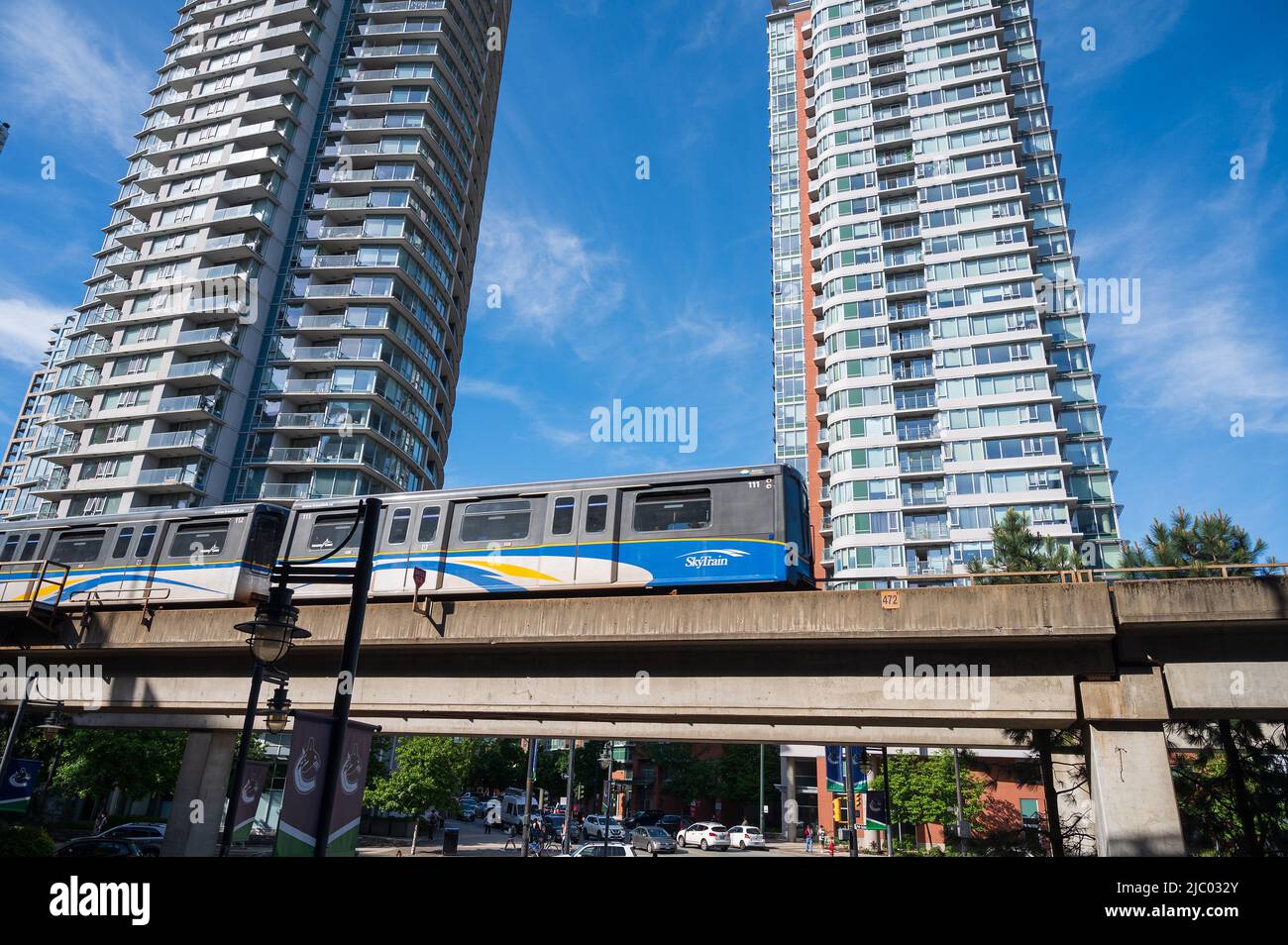 A Vancouver Sky Train rapid transit train rolls past downtown Vancouver condominium towers.  Vancouver BC, Canada. Stock Photo