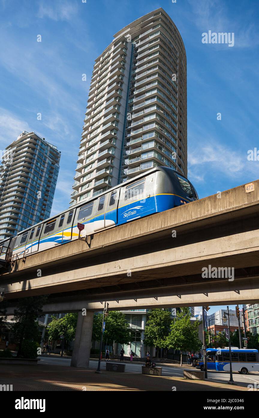 A Vancouver Sky Train rapid transit train rolls past downtown Vancouver condominium towers.  Vancouver BC, Canada. Stock Photo
