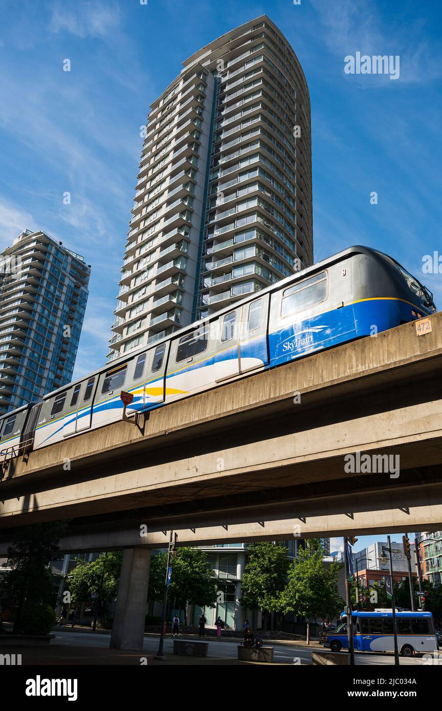 A Vancouver Sky Train rapid transit train rolls past downtown Vancouver condominium towers.  Vancouver BC, Canada. Stock Photo