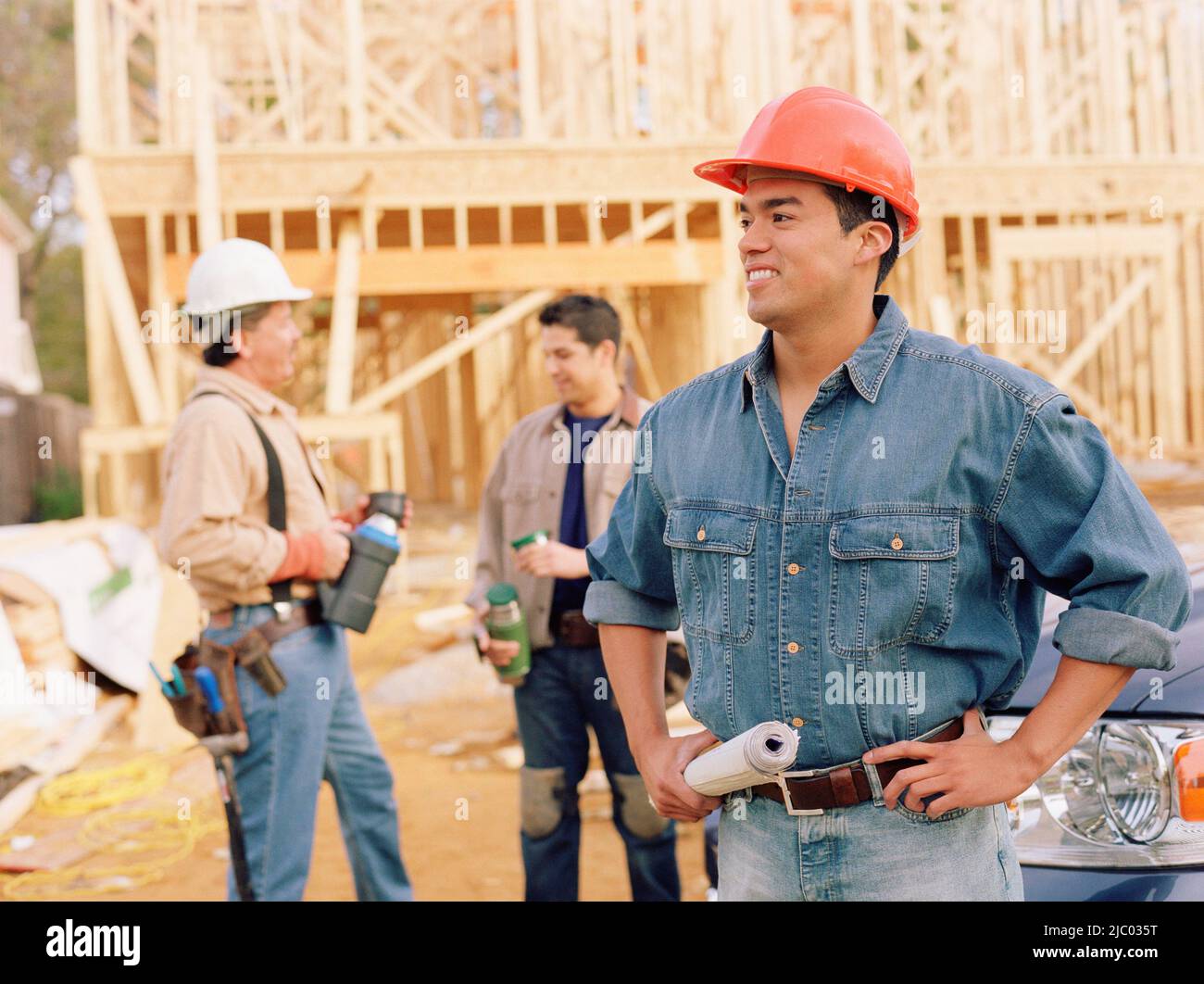 Manual worker holding blueprints on site Stock Photo - Alamy