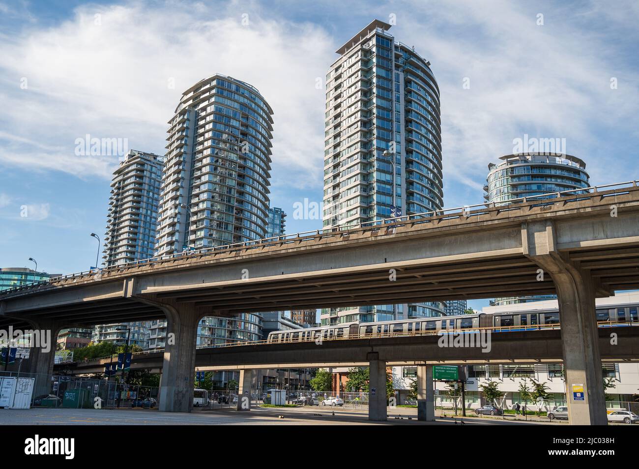 A Vancouver Sky Train rapid transit train rolls past the Georgia viaduct in downtown Vancouver with condominium towers in the background.  Vancouver B Stock Photo