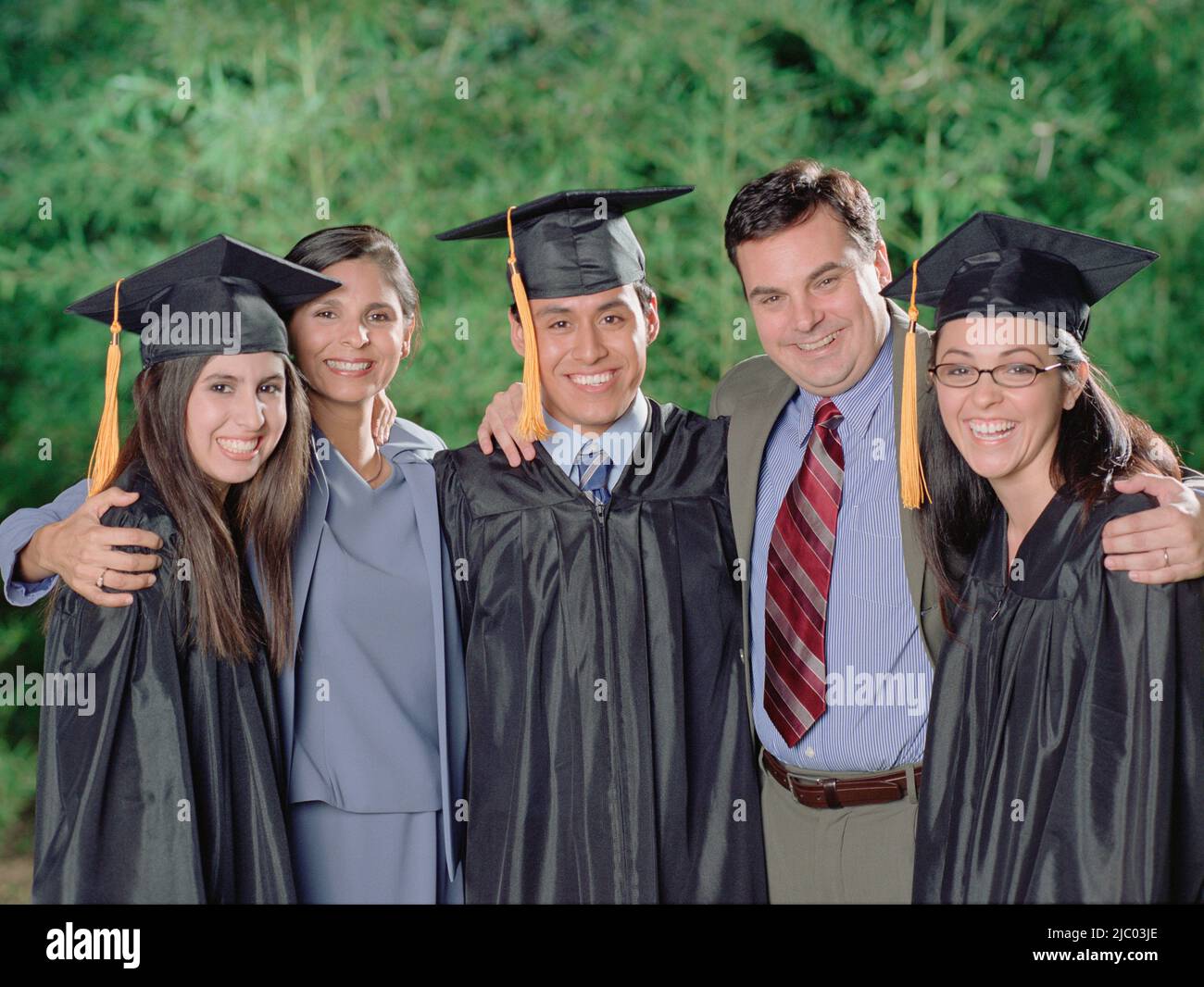 Graduates smiling for the camera with their parents Stock Photo