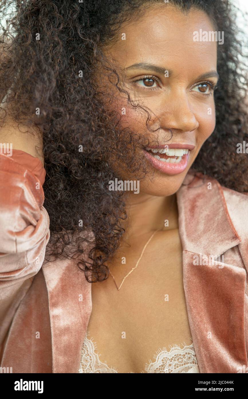 Close-up portrait of a middle-J54aged woman looking off camera running a hand through her hair. Stock Photo