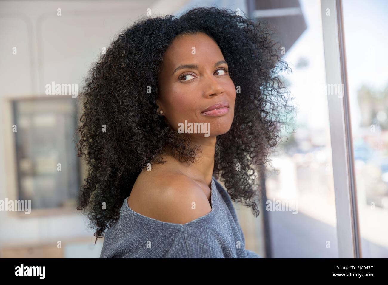 Middle-aged woman looks back over her shoulder. Stock Photo