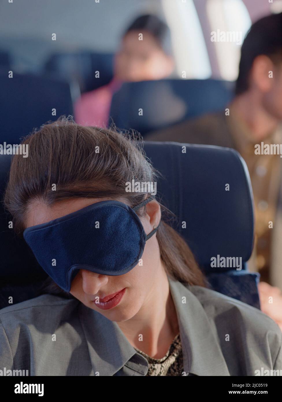 Young woman sleeping on airplane with eye mask Stock Photo Alamy