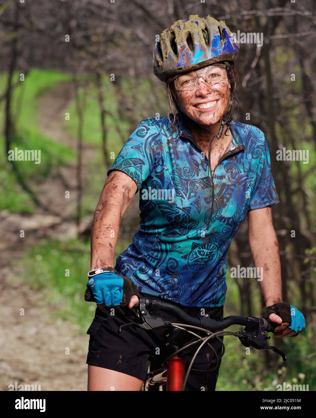 Portrait of muddy young woman on bike Stock Photo - Alamy
