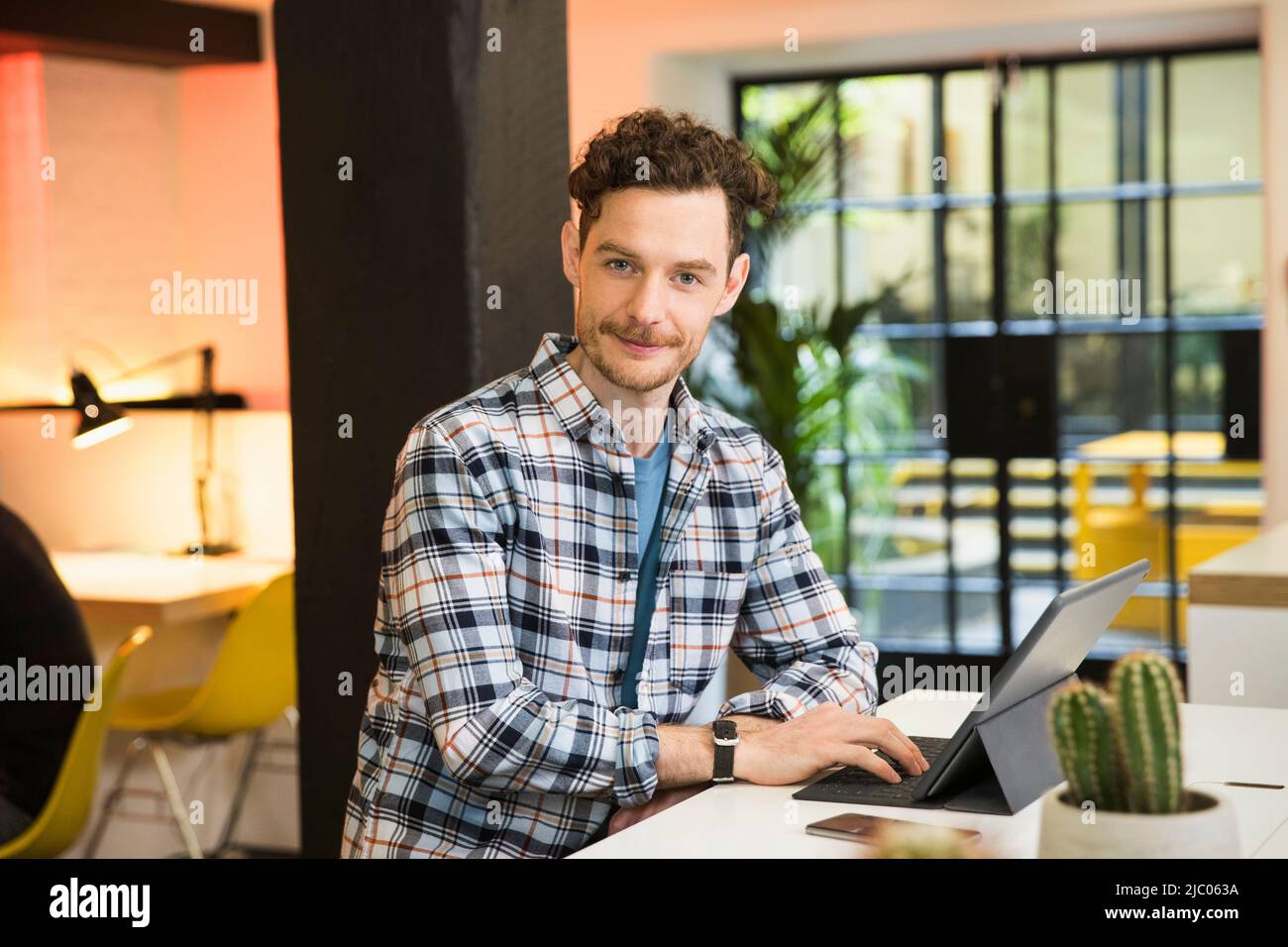 Young man in co-working space working on tablet Stock Photo