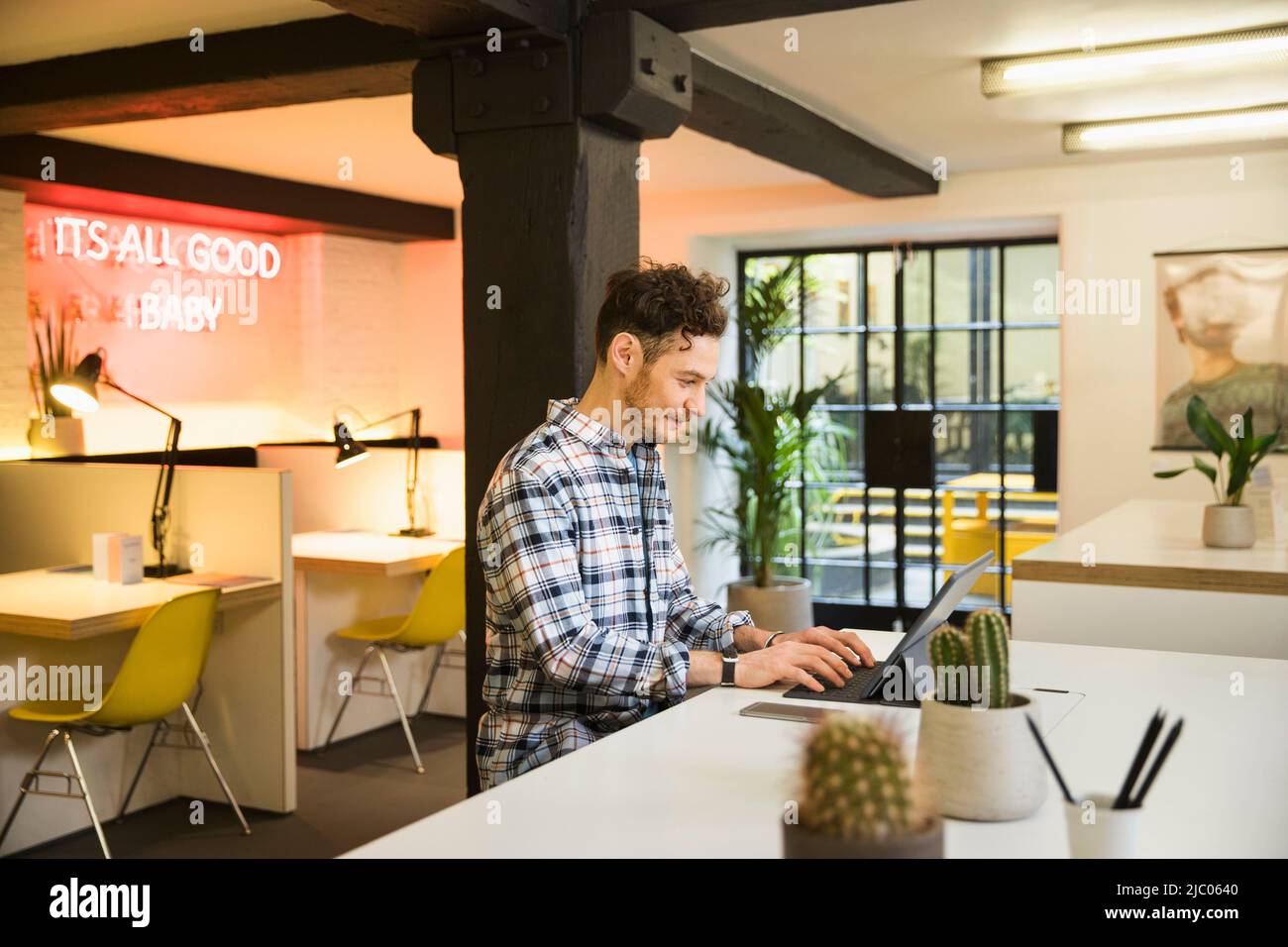 Young man in co-working space working on tablet Stock Photo