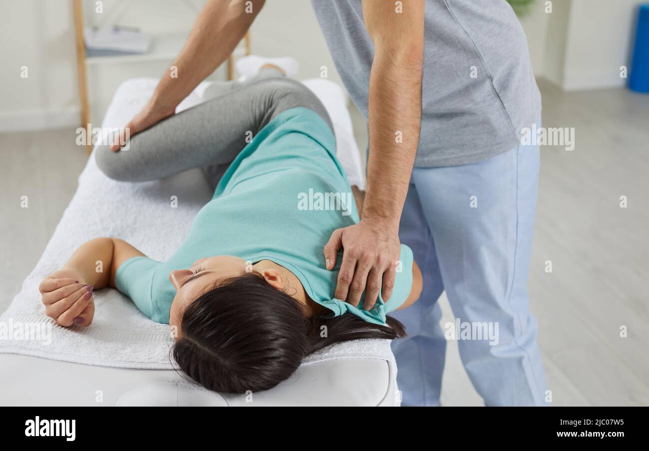 Physiotherapist work with female patient in clinic Stock Photo