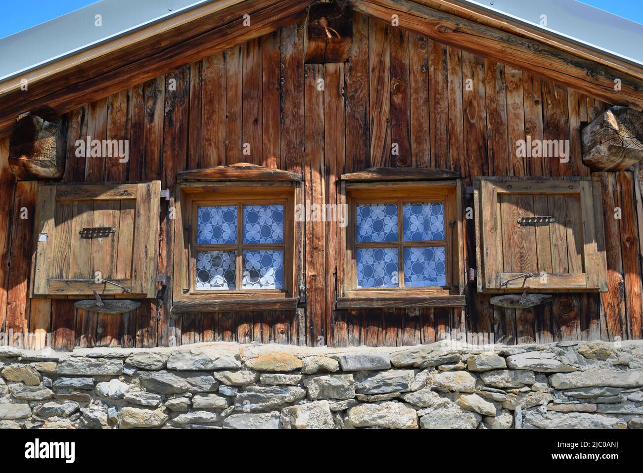 part of a traditional wooden alpine chalet with two little windows Stock Photo