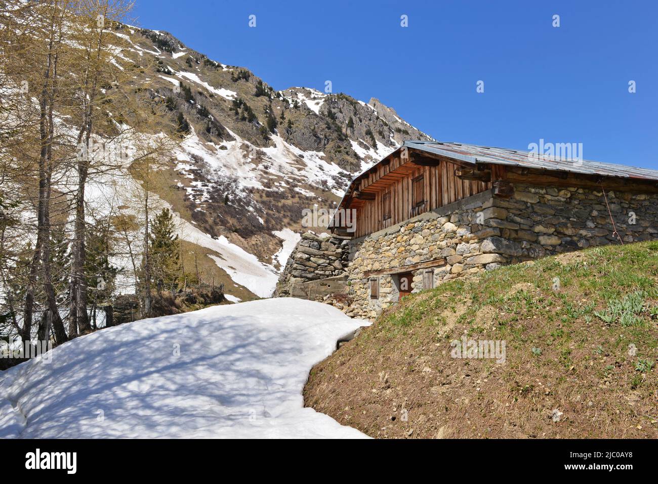 traditional alpine chalet with snowy road Stock Photo