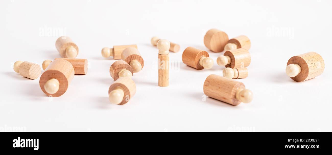 Standing Montessori cylinder like winner, survivor among lying ones. Wooden childish game. Single person was able to overcome obstacles. High quality photo Stock Photo