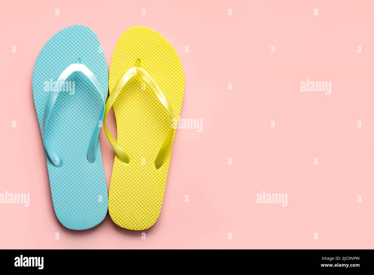 Summer holiday concept.Top view of colored beach flip flops with space for text over pink background Stock Photo