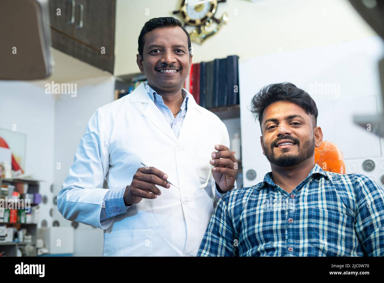Portrait shot of happy smiling patient with dental doctor or dentist at hosptial looking at camera - concept of oral care, diagnosis and treatment Stock Photo