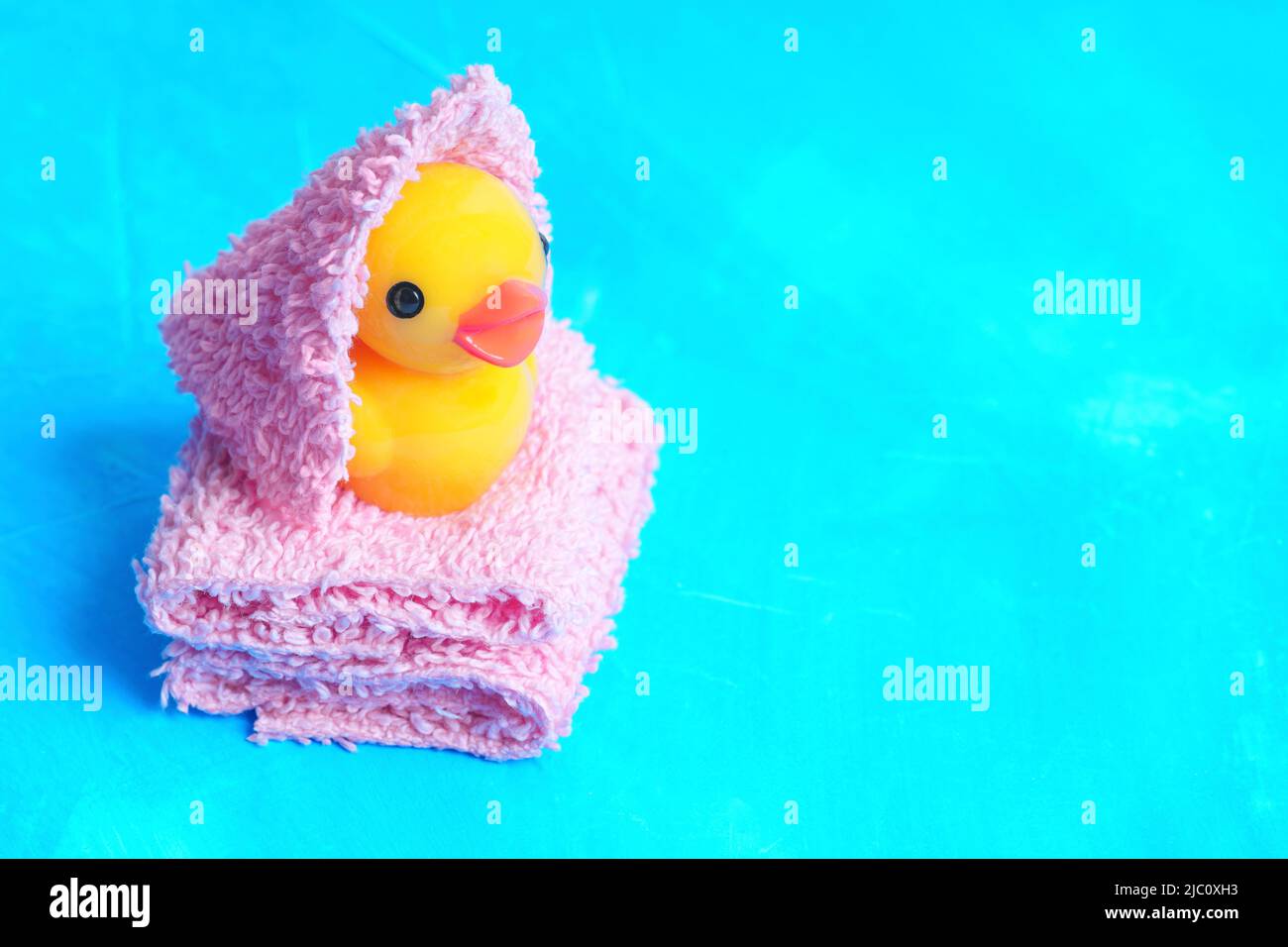 Baby duck wrapped in a towel and placed on a pile of soft towels on