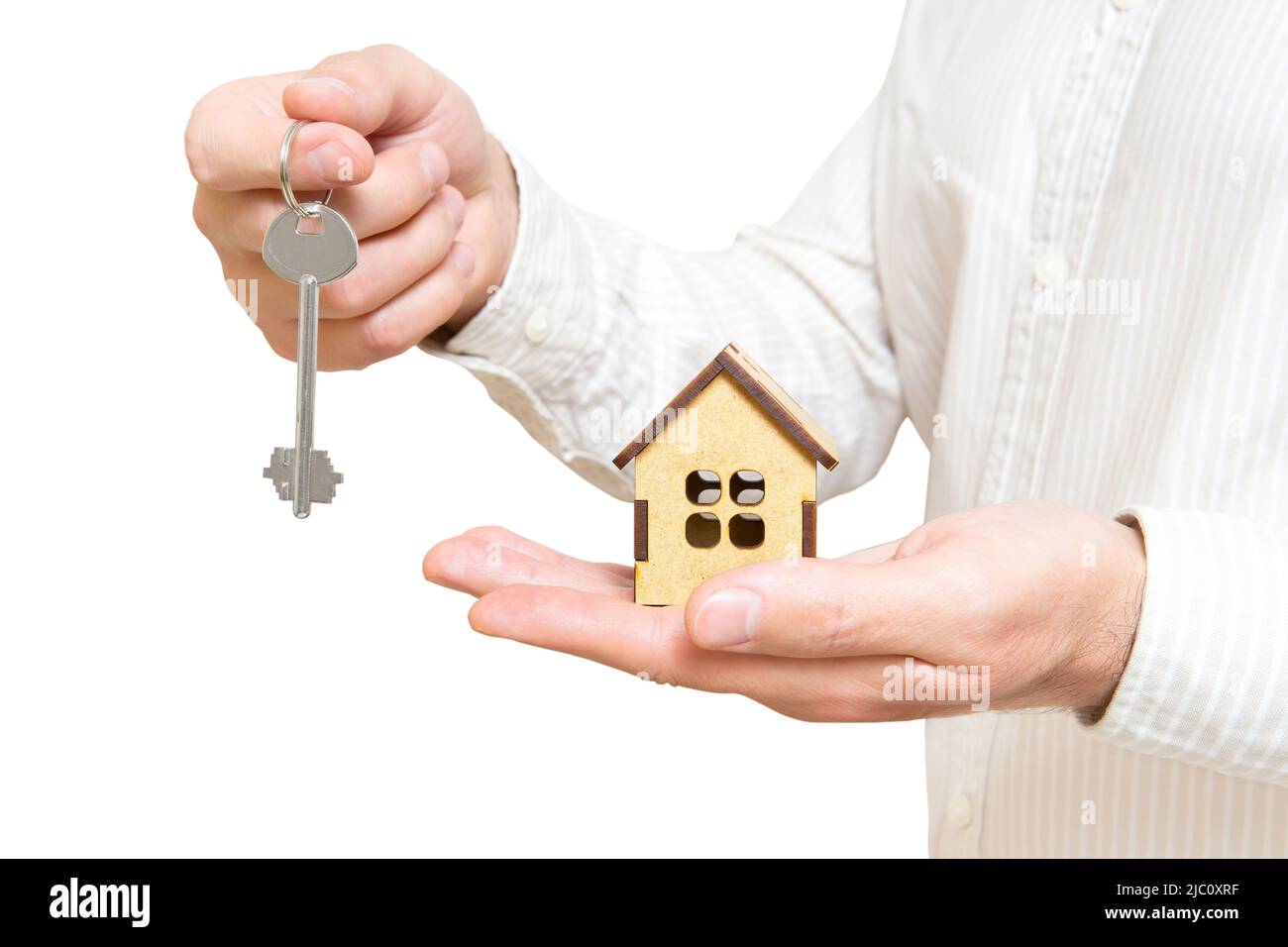 Realtor holding a miniature wooden house model and a house key in hands ...