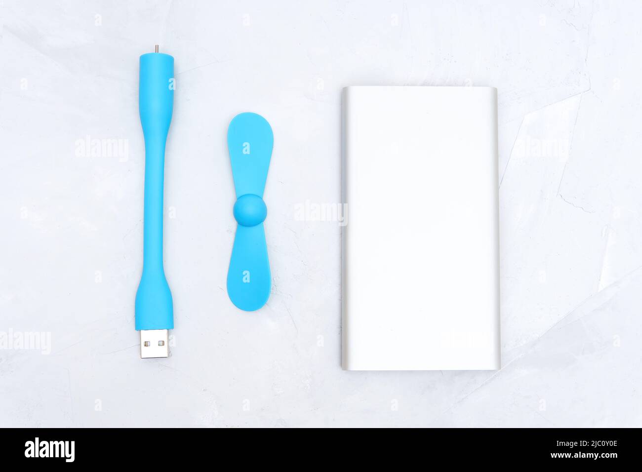 Portable usb fan and a slim silver power bank isolated on a neutral