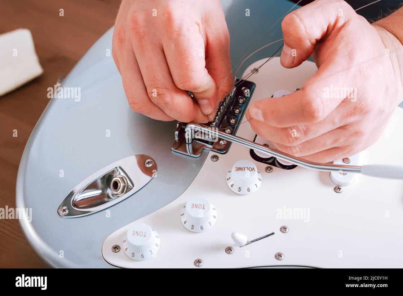 Guitar master making professional guitar maintenance, hands with tools