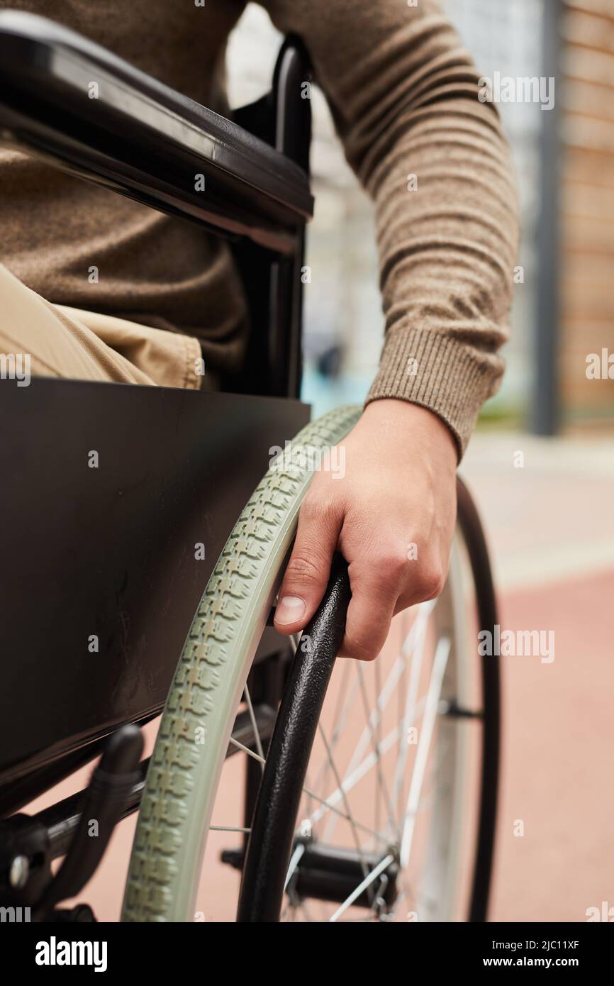 Closeup of unrecognizable handicapped man sitting in manual wheelchair