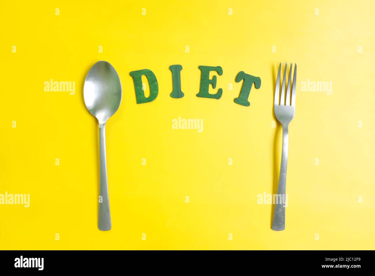 Diet and nutrition concept. Fork, spoon and plate with DIET letters in