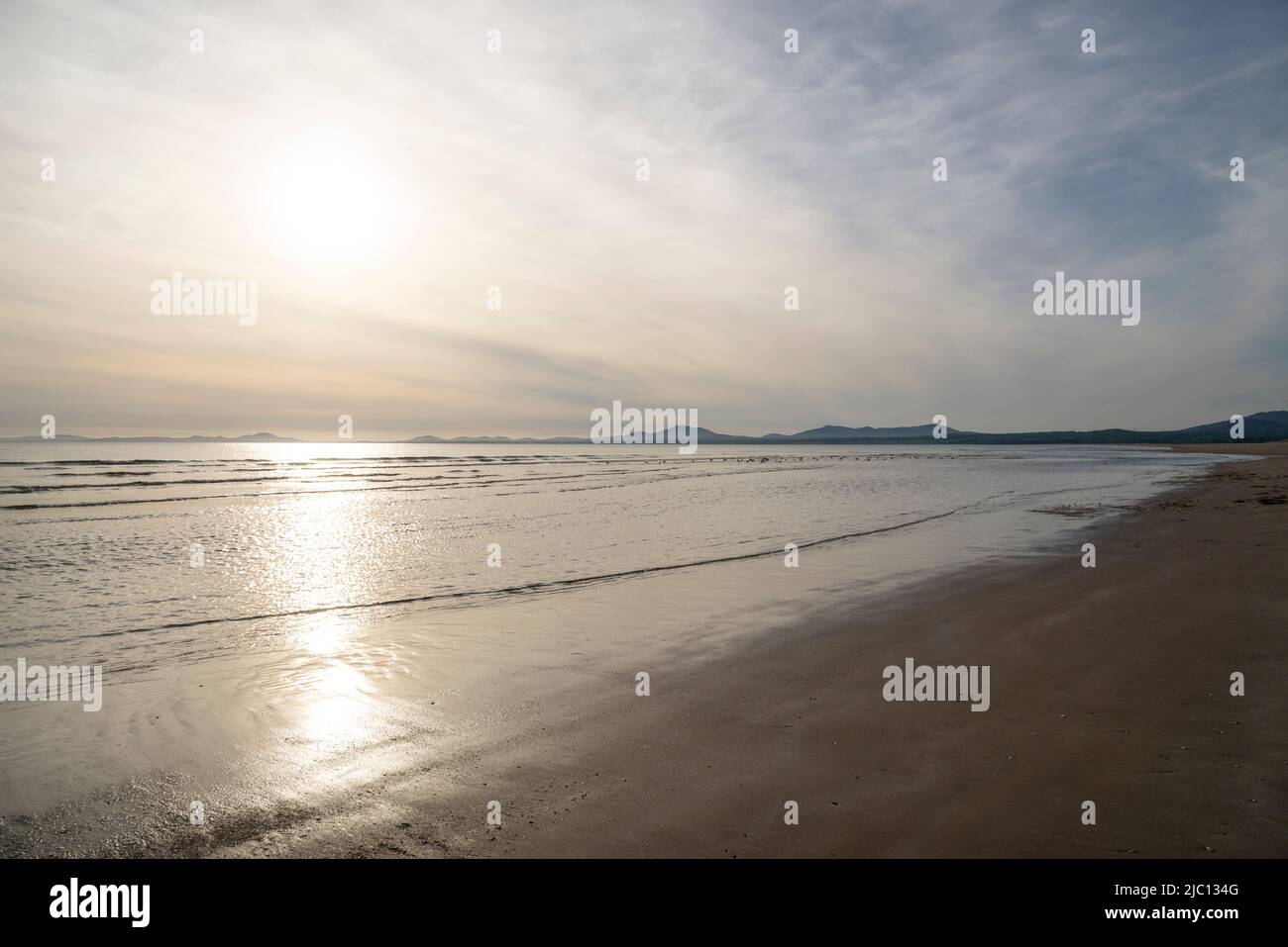Low sunlight at Harlech Beach on the coast of North Wales. View north to the hills of the Lleyn Peninsula. Stock Photo