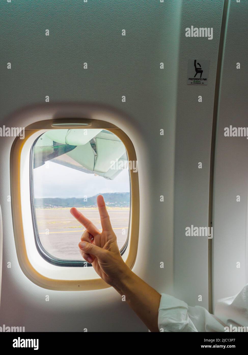 Anonymous traveler showing v sign near illuminator Stock Photo