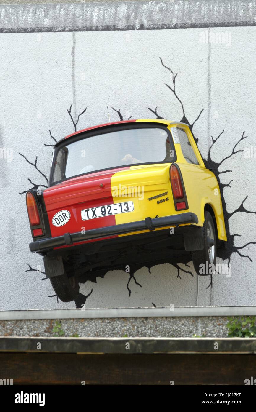 black red gold german Trabbi stucking in house wall, Germany Stock Photo