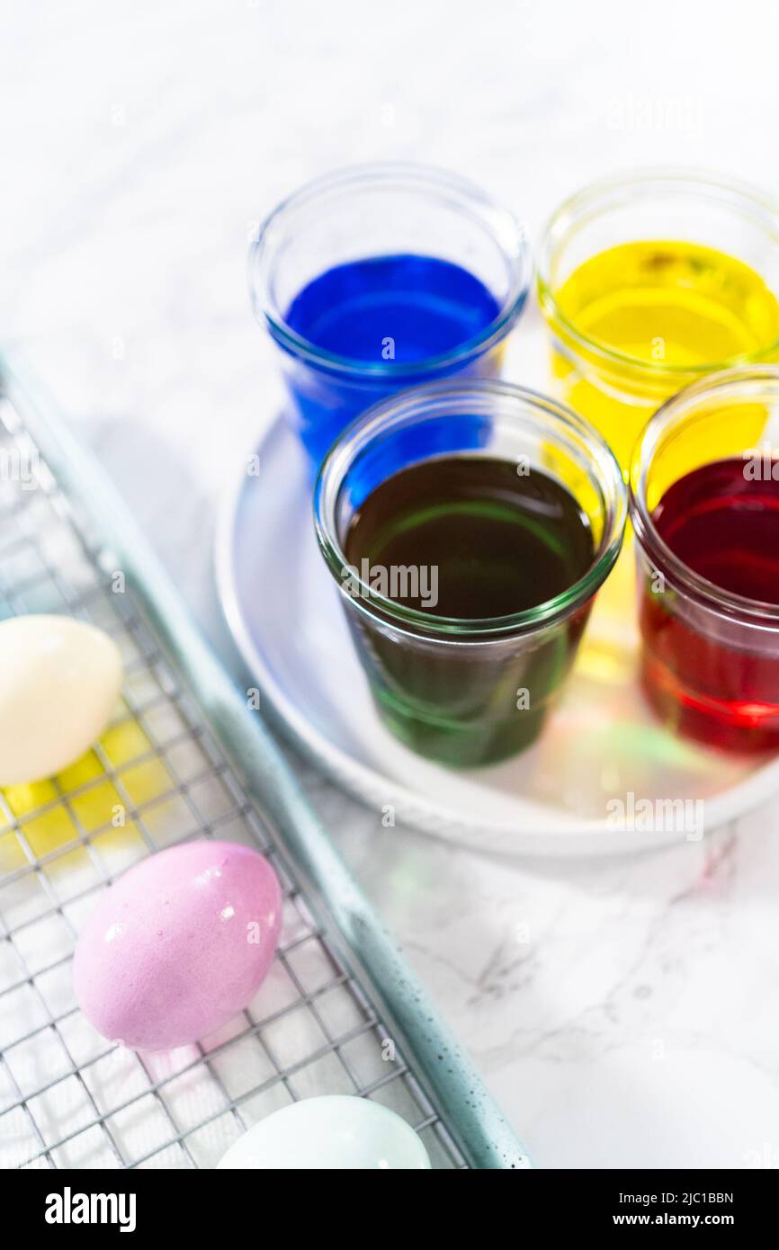 Coloring hardboiled white eggs with natural food coloring Stock Photo