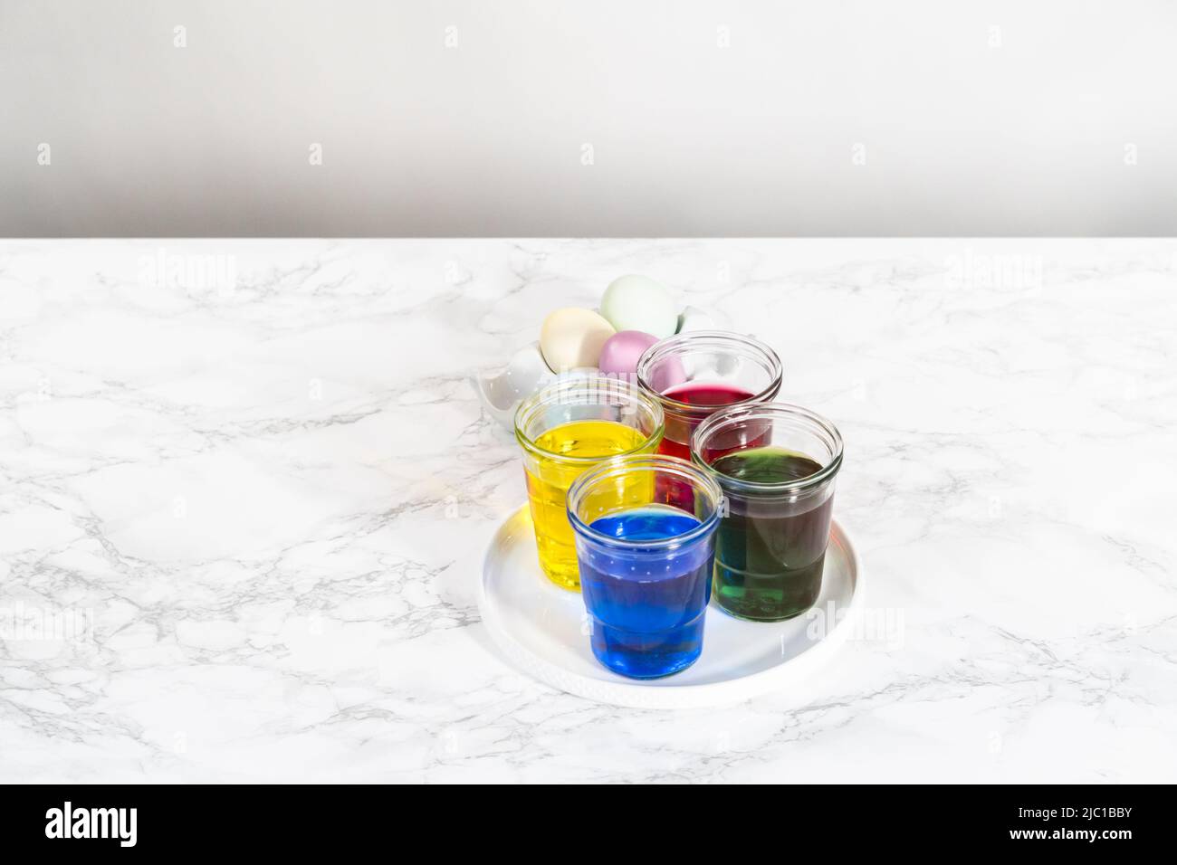 Coloring hardboiled white eggs with natural food coloring Stock Photo