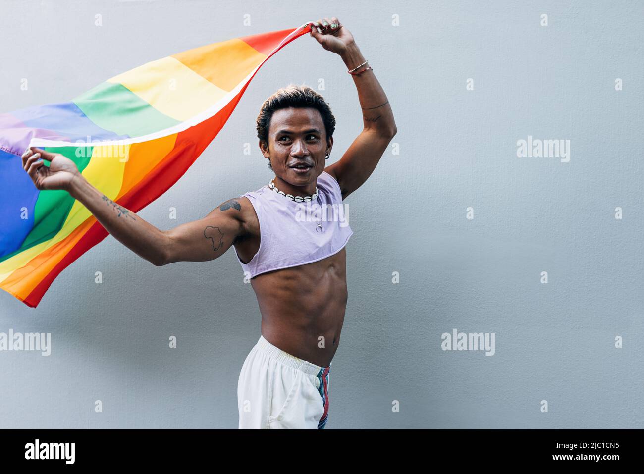 Young man holding gay rainbow flag hi-res stock photography and images ...