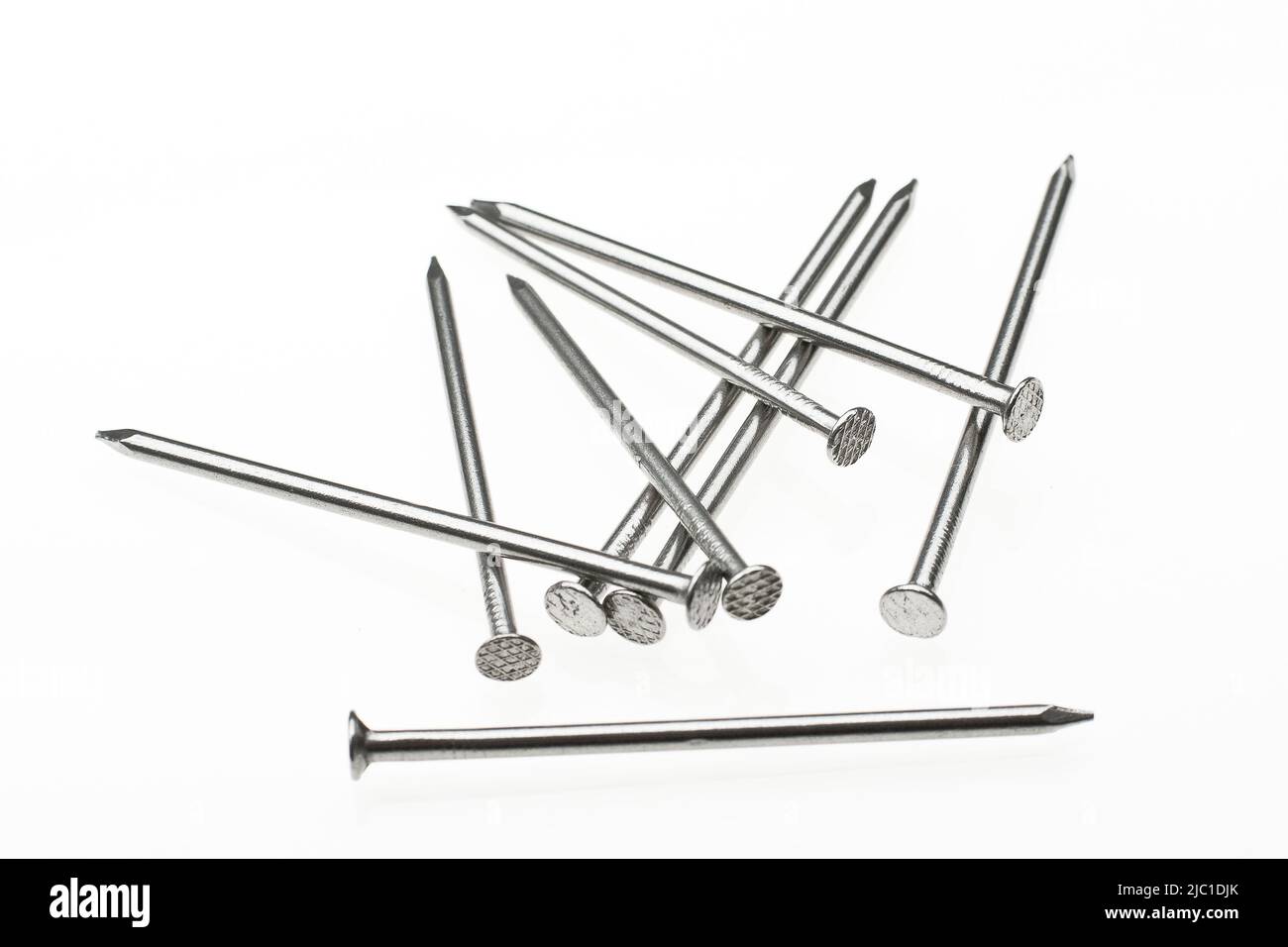 a bunch of nails on a white surface Stock Photo Alamy